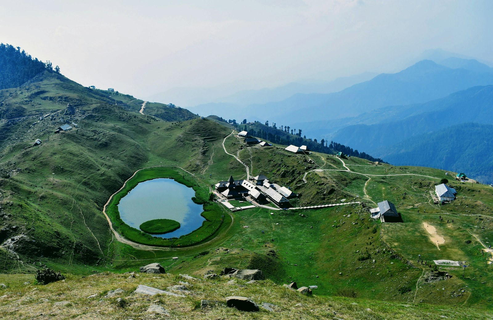 A small lake among forested hills in Mandi, Himachal Pradesh.