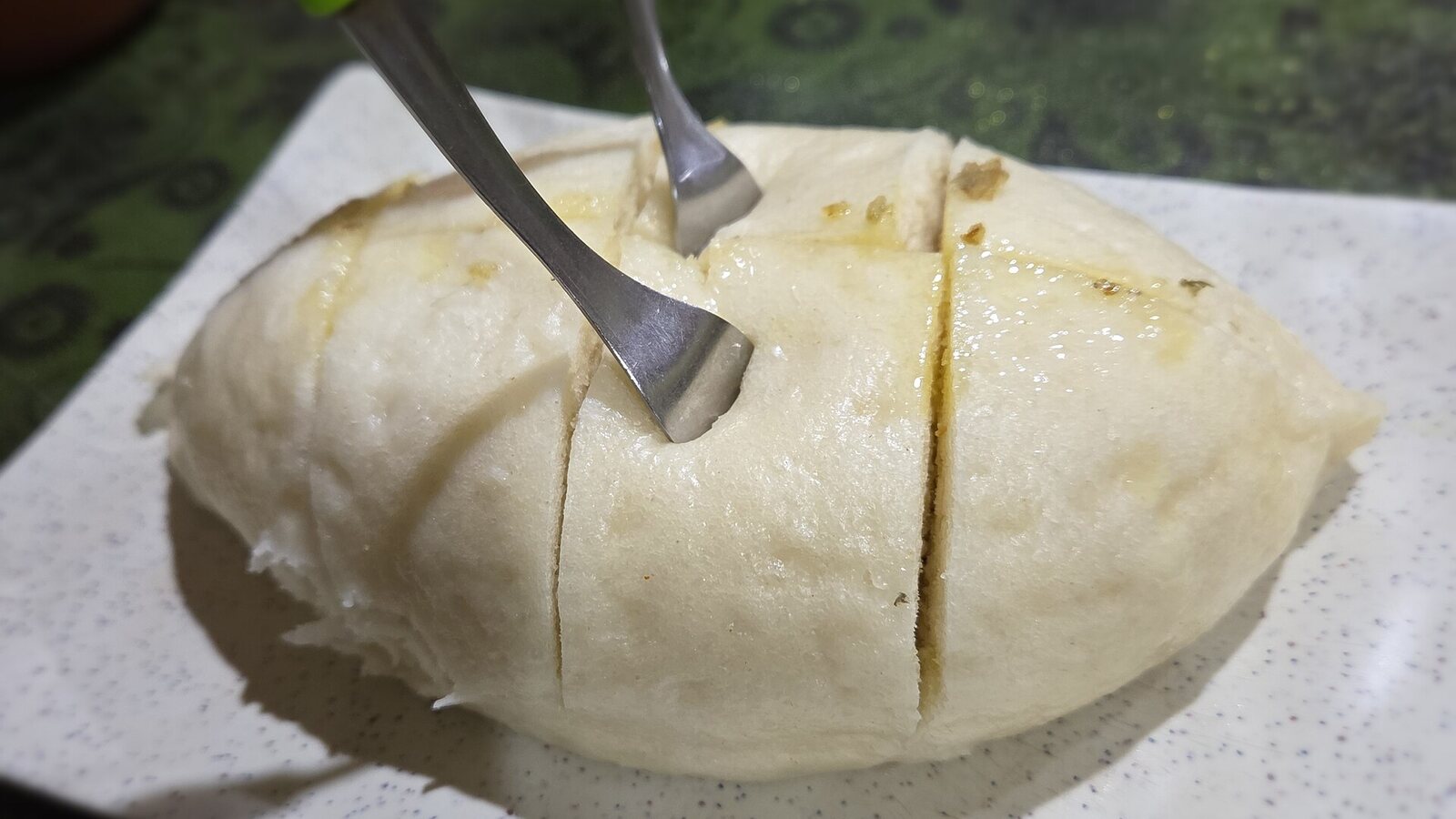 Steamed Himachali siddu cut open on a plate.